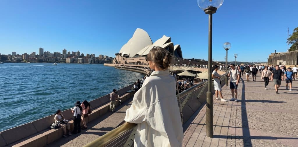 Pessoa junto ao porto de Sydney, com a Ópera ao fundo