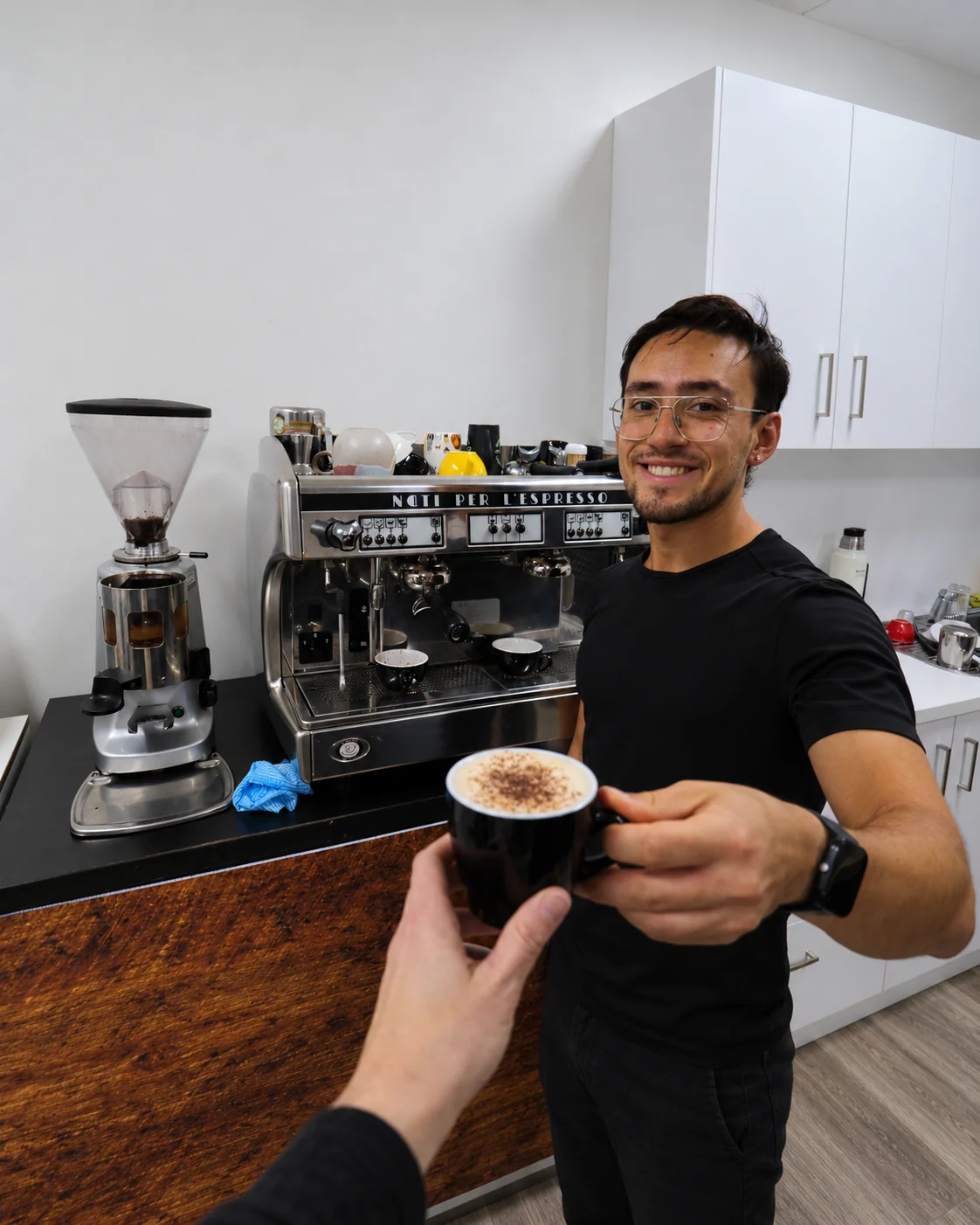 Participante de un taller de barista de Nómadas ofreciendo un café